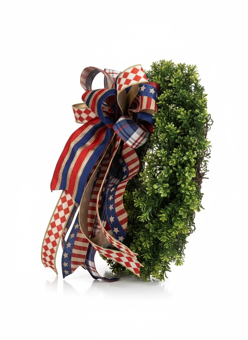 Chic Collective patriotic bow with red, white, and blue ribbons featuring stars and stripes patterns on a green wreath.