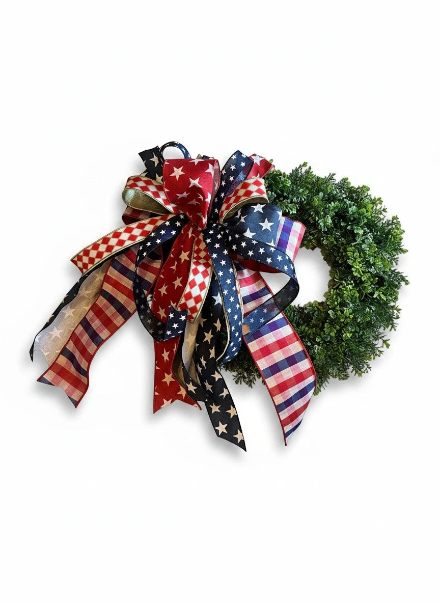 Chic Collective patriotic wreath with red, white, and blue star, stripe, and checkered ribbon bow on green foliage.