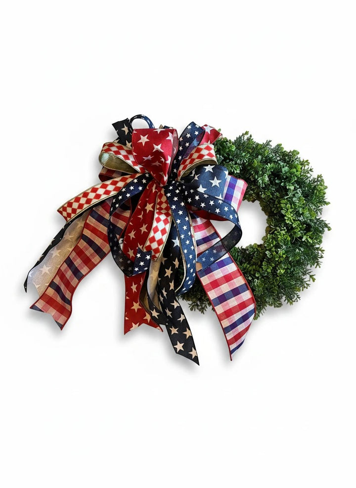 Chic Collective patriotic wreath with red, white, and blue star, stripe, and checkered ribbon bow on green foliage.
