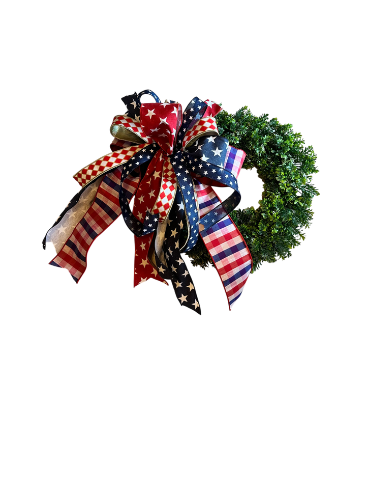 Chic Collective patriotic wreath with red, white, and blue star, stripe, and checkered ribbon bow on a lush green base.