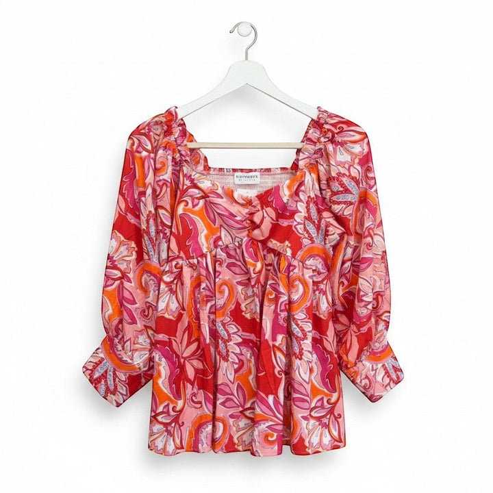 Chic Collective babydoll top with a vibrant pink, red, and orange paisley print. Features a square neckline and long sleeves.