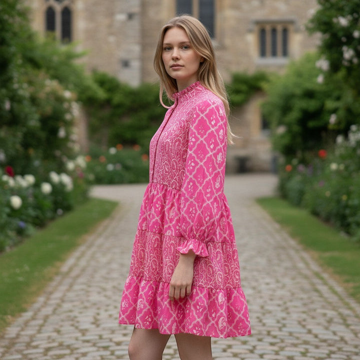 Chic Collective pink and white tiered mini dress with a high neckline and long sleeves, featuring a geometric and paisley print.