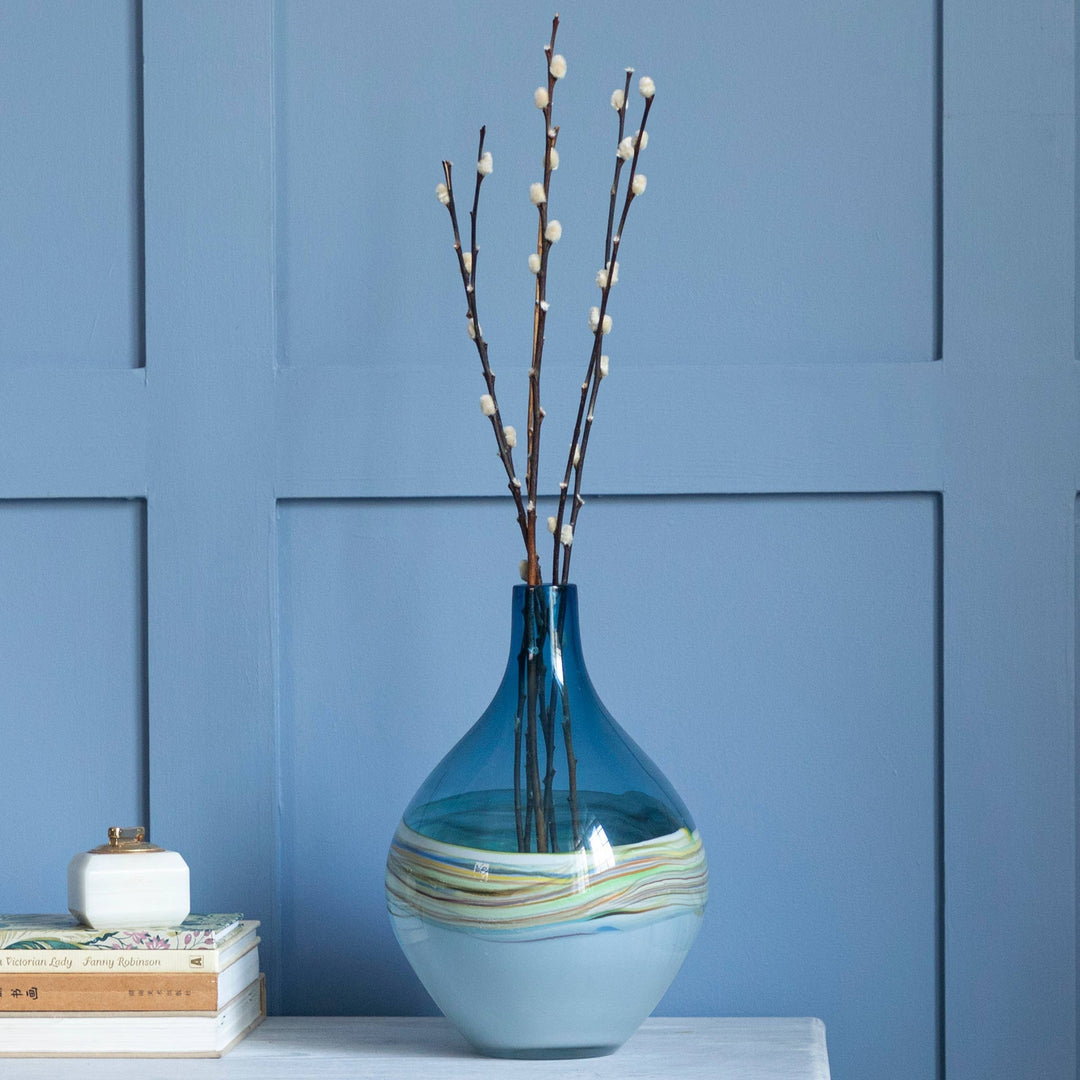 Chic Collective Rhian round hand-blown glass vase with painterly waves in blue, white, yellow, and green.