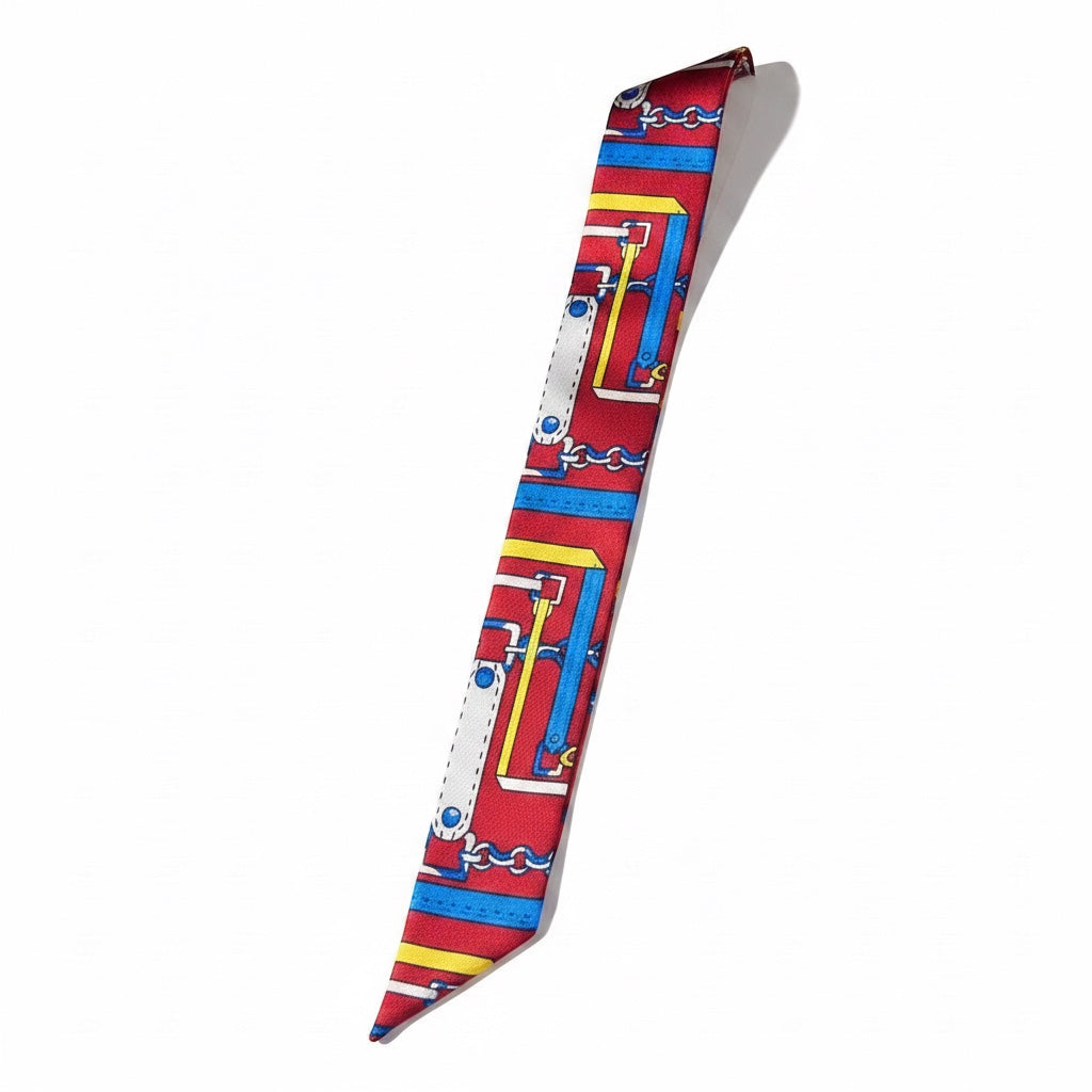 Chic Collective Riviera Ribbon Tie scarf with equestrian chain motif in red, blue, yellow, and ivory.