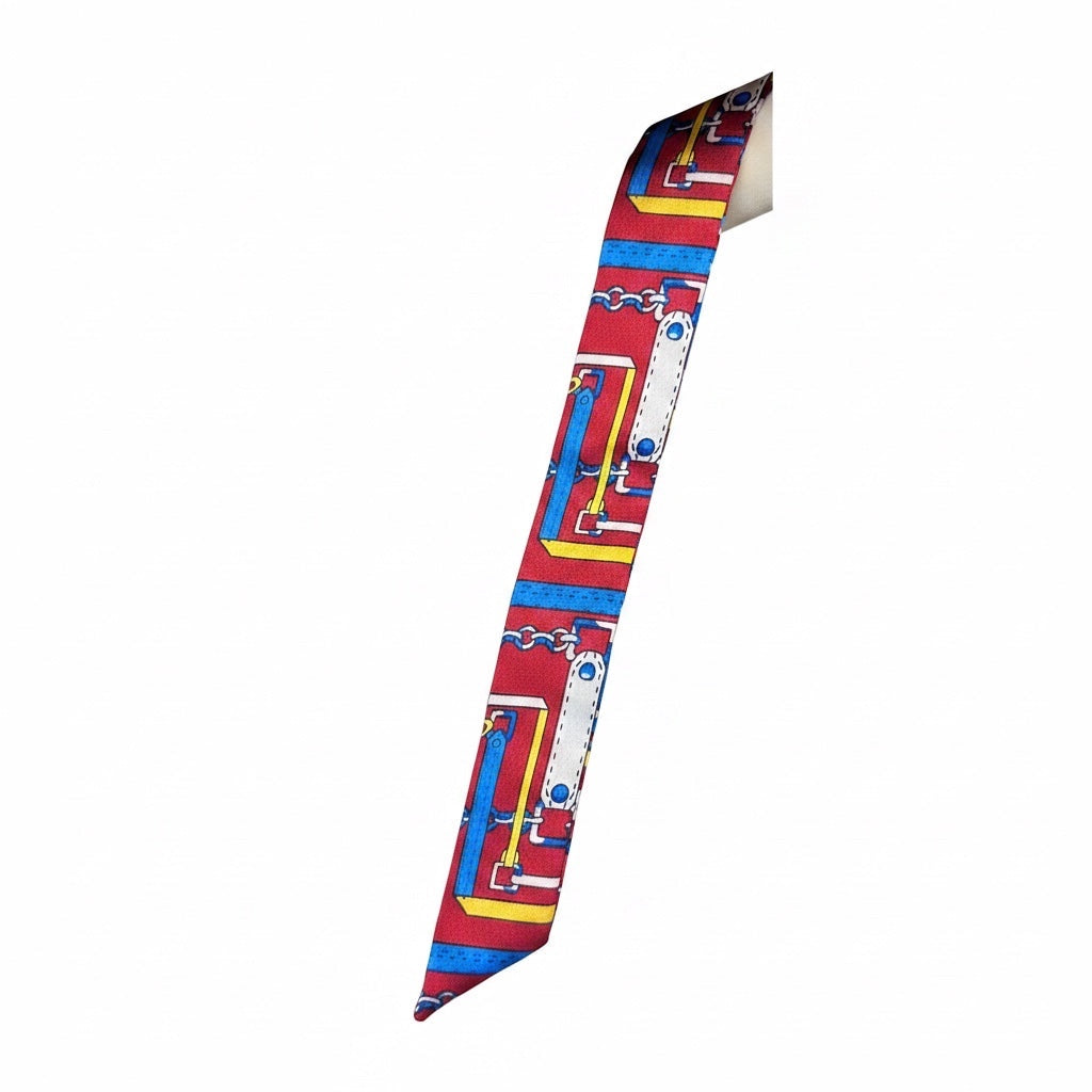 Chic Collective Riviera Ribbon Tie scarf in red with equestrian chain motif in blue, yellow, and white. Silky satin finish.