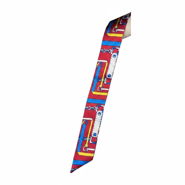 Chic Collective Riviera Ribbon Tie scarf in red with equestrian chain motif in blue, yellow, and white. Silky satin finish.