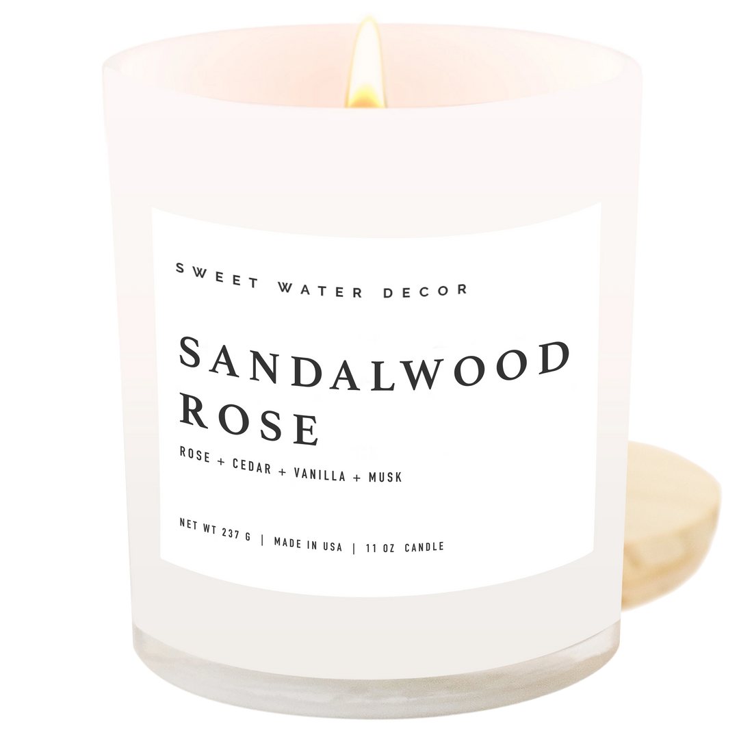 Chic Collective Sandalwood Rose 11 oz soy candle with a white label and a lit wick. Notes of rose, cedar, vanilla, and musk.