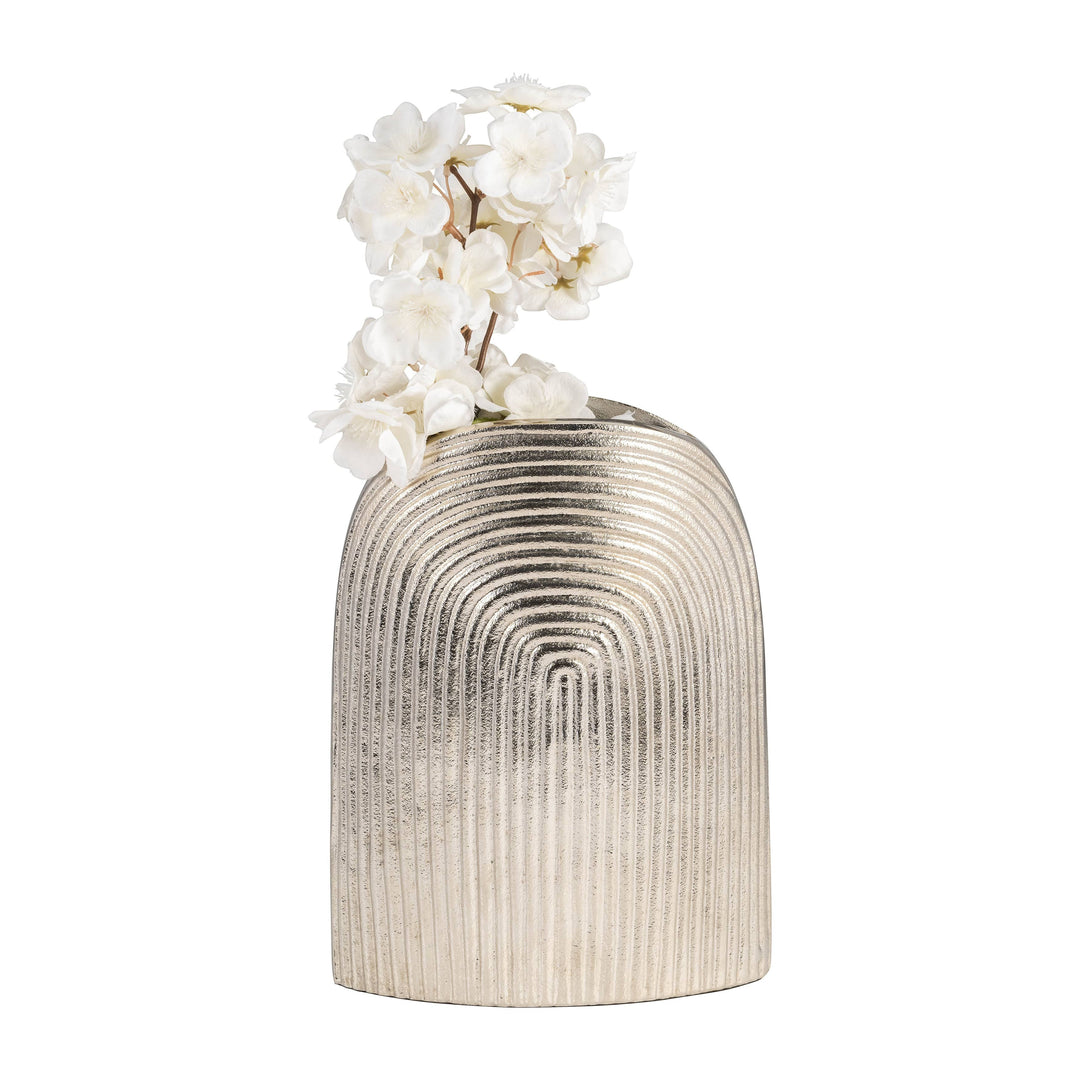 Chic Collective silver aluminum arch vase with striped texture, holding white flowers.