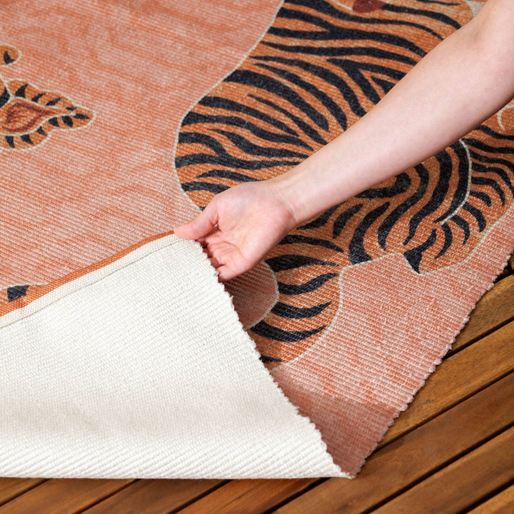 Chic Collective coral orange polyester flatweave rug with a Tibetan tiger design, 120x170cm. Washable and versatile for indoor/outdoor use.