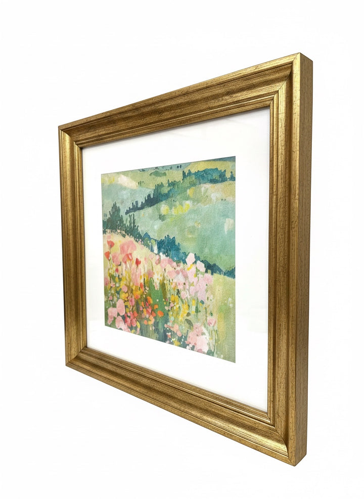Chic Collective Where Wildflowers Wander framed art print, featuring a soft, romantic landscape with blush pink florals, golden wildflowers, and sage-green hills.