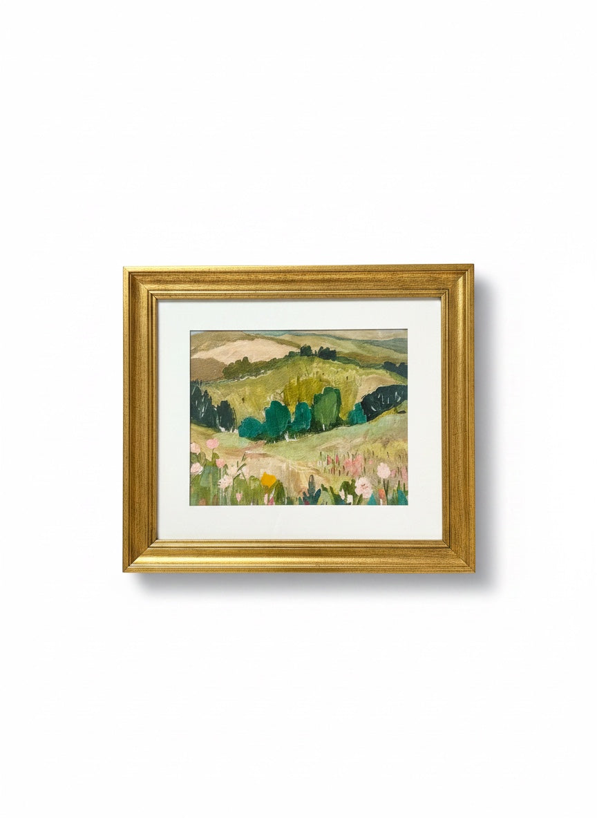Chic Collective Whispering Hills framed landscape painting with rolling green hills and floral foreground in muted olive, sage, blush, and blue.