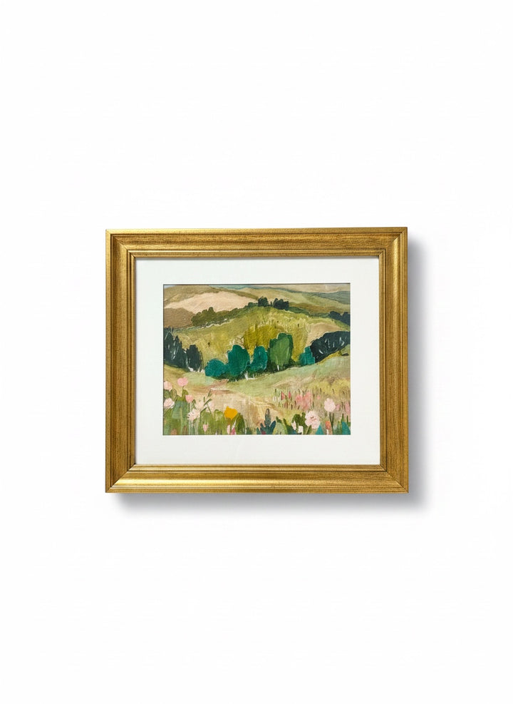 Chic Collective Whispering Hills framed landscape painting with rolling green hills and floral foreground in muted olive, sage, blush, and blue.