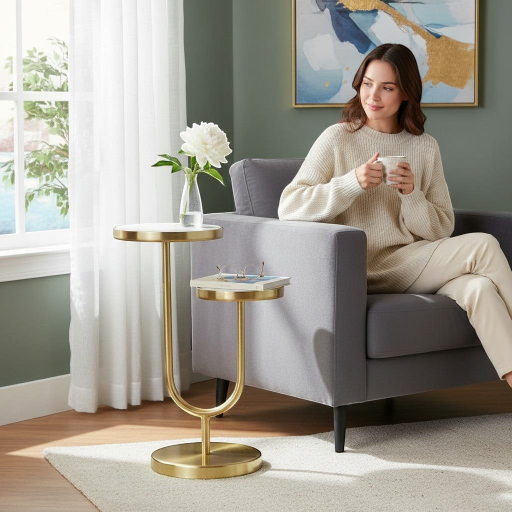 Chic Collective 22" white marble and gold iron two-tier round end table with a U-shaped base, perfect for living rooms or bedrooms.