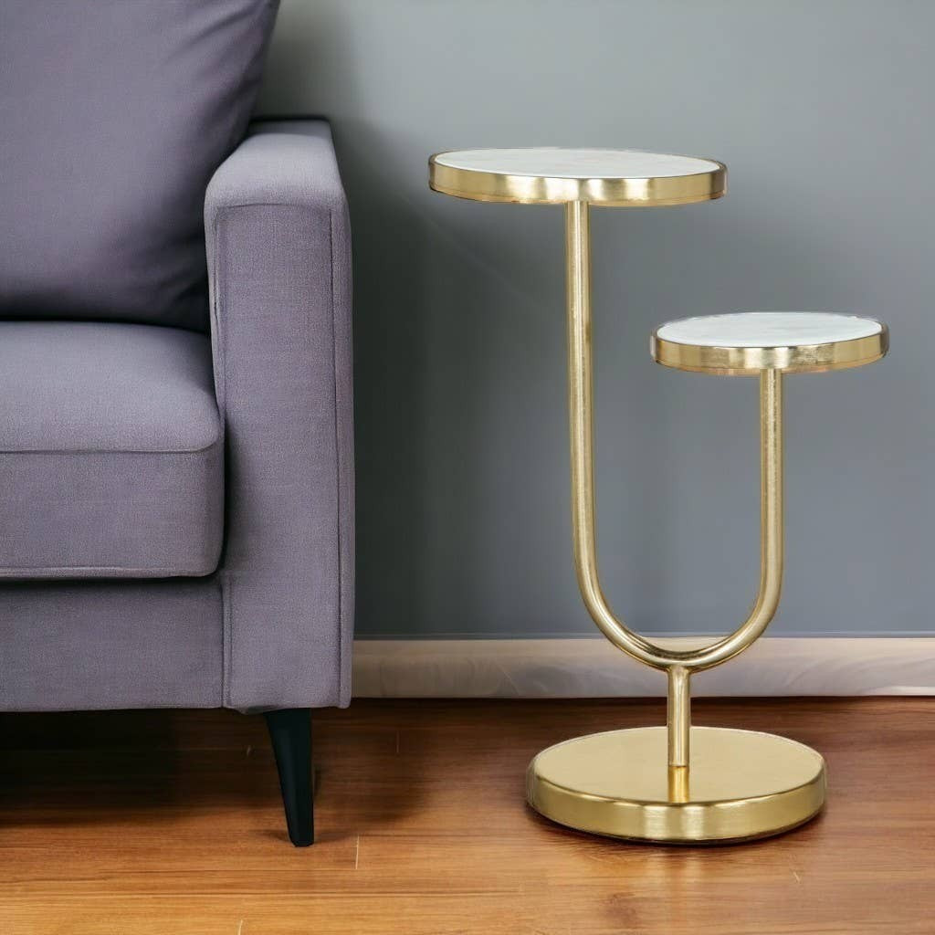 Chic Collective 22" two-tier round end table with white marble tops and gold iron base, next to a grey sofa.