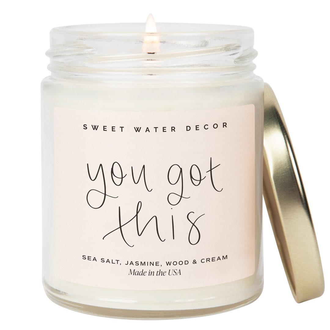 Chic Collective You Got This 9 oz soy candle with Spa Day scent notes of sea salt, jasmine, wood, and cream.