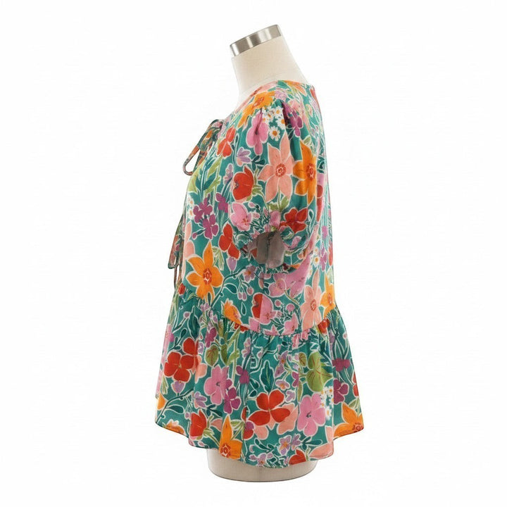 Chic Collective aqua blouse with colorful floral print, ribbon bow detail, short sleeves, and ruffled hem.