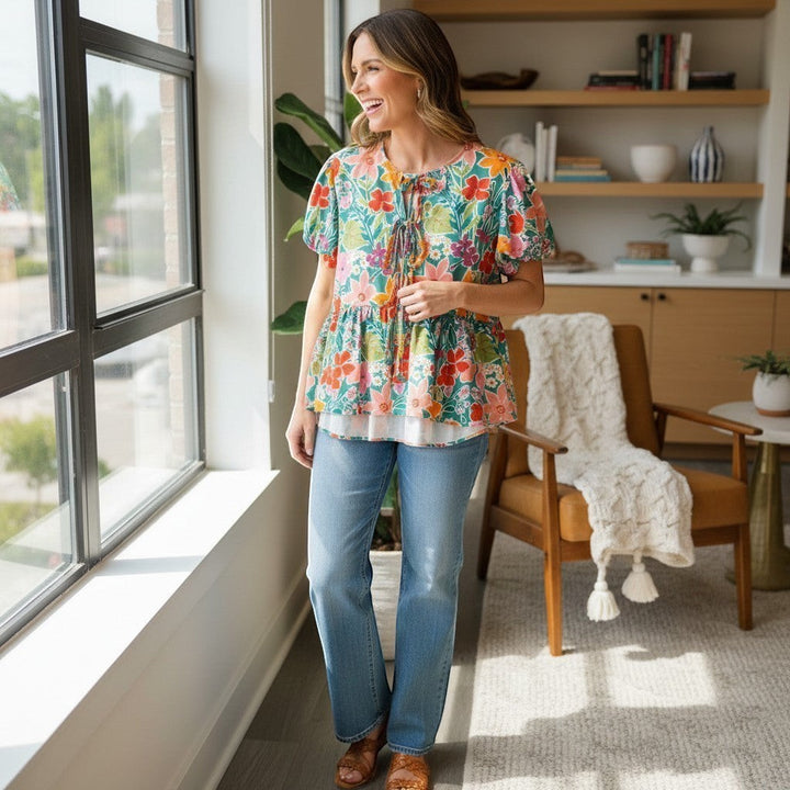 Chic Collective Aqua Colorful Ribbon Bow Floral Woven Blouse with short sleeves and tie neck, paired with light wash jeans.