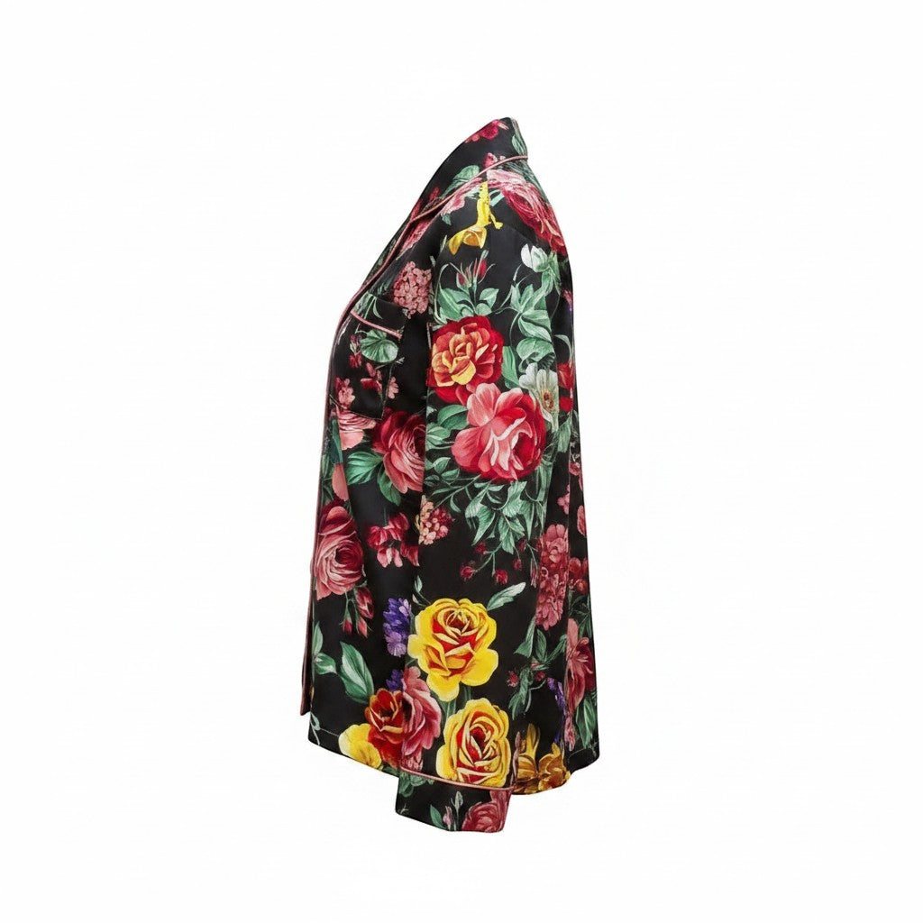 Chic Collective black satin pajama set with a vibrant floral print of red, yellow, and pink roses. Features a collared neckline and pink piping.