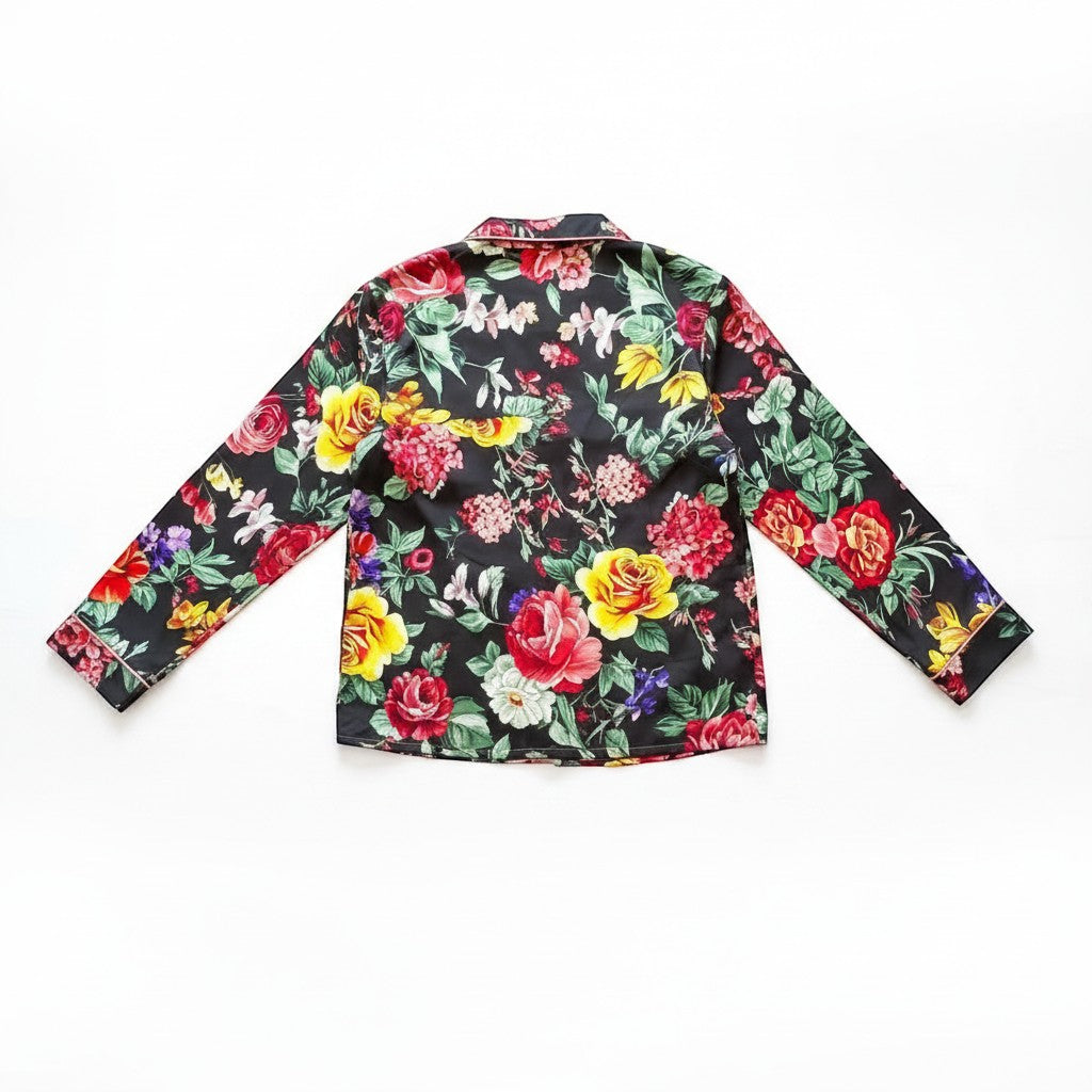 Chic Collective black satin pajama set with a vibrant floral print, long sleeves, and pink piping detail.