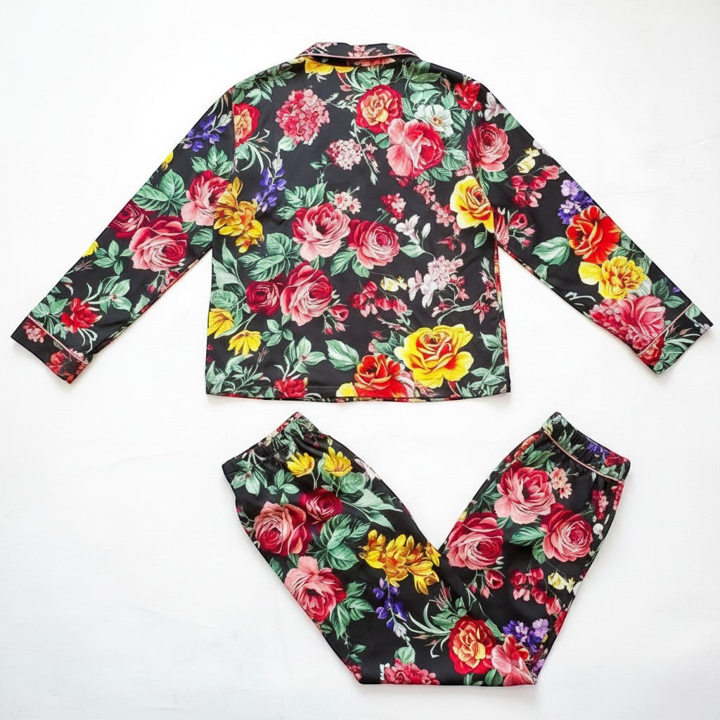 Chic Collective black floral satin pajama set with long sleeves and pants. Features vibrant red, yellow, and pink roses.