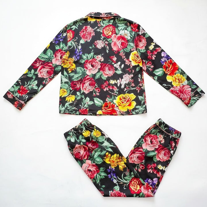 Chic Collective black floral satin pajama set with long sleeves and pants. Features vibrant red, yellow, and pink roses.
