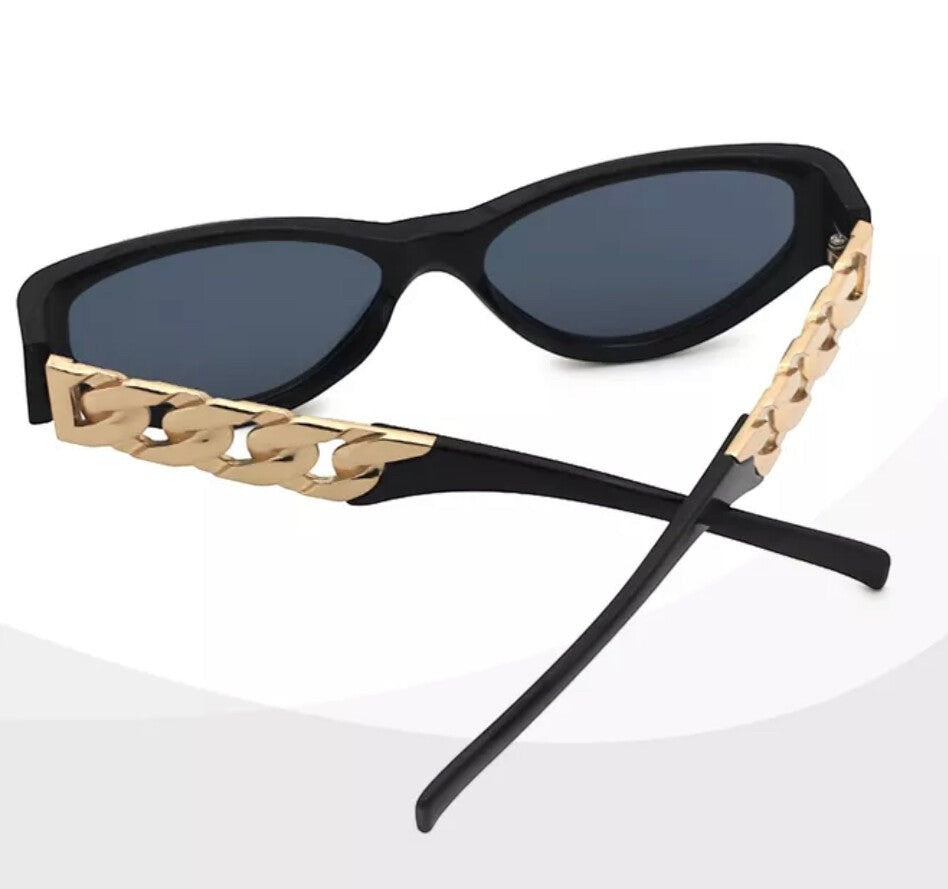 Chic Collective black cat-eye sunglasses with gold chain accents on temples and dark polarized lenses.