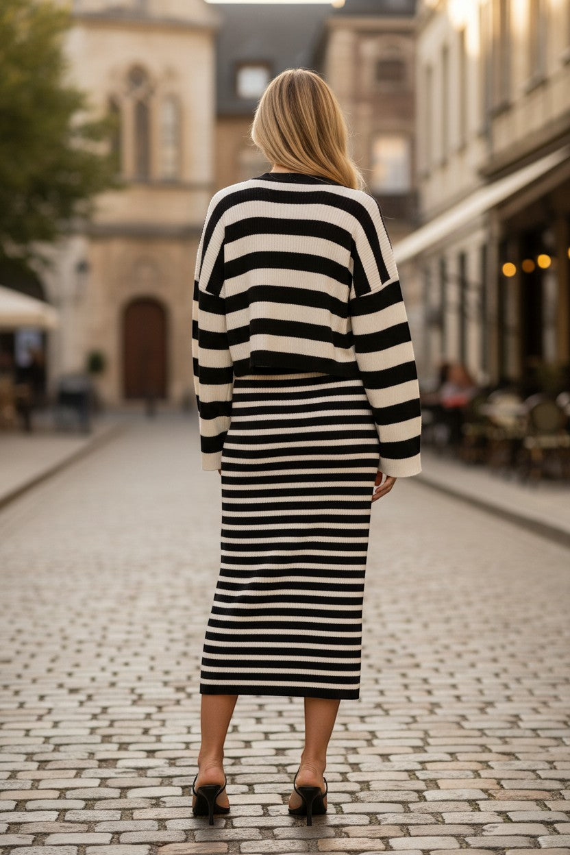 Chic Collective black and white striped knit sweater and midi skirt set on a woman.