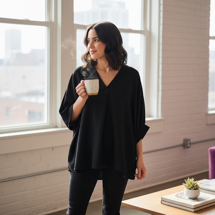 Chic Collective black woven airflow v-neck puff half-sleeve top on a woman holding a mug.