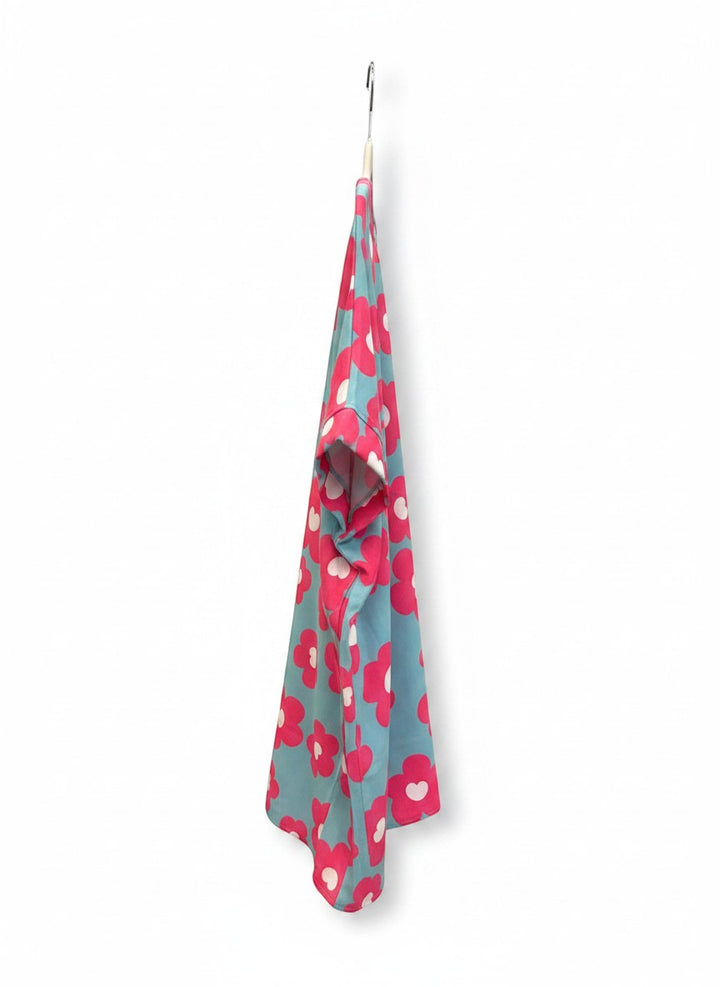 Chic Collective blue V-neck top with large pink and white floral print, short cuffed sleeves.