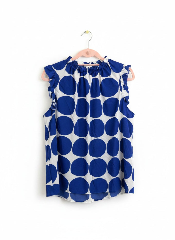 Chic Collective blue and white polka dot sleeveless blouse with ruffle neckline and sleeves.