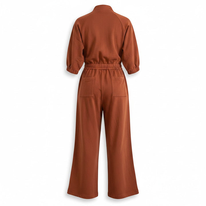 Chic Collective brown cotton jumpsuit with elasticated waist, wide legs, and patch pockets. Mock neck and puffed sleeves.