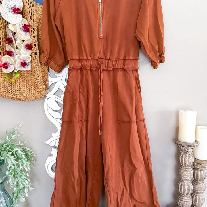 Chic Collective brown terry cloth jumpsuit with quarter zip, drawstring waist, and wide legs. Casual loungewear.