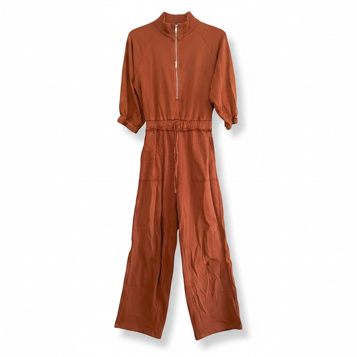 Chic Collective rust brown wide-leg jumpsuit with quarter zip neckline, drawstring waist, and cuffed sleeves.