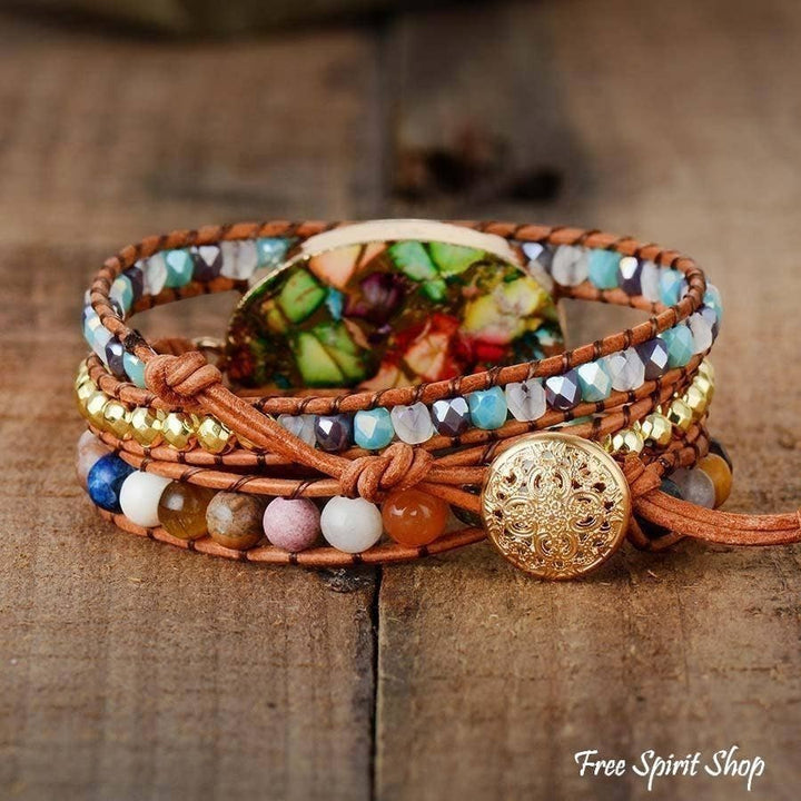 Chic Collective handmade boho wrap bracelet with color splash jasper, natural stones, and genuine leather on a wooden background.