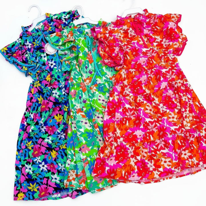 Chic Collective vibrant floral print dresses in green, blue, and red. Short-sleeved, tiered skirts, and ruffled necklines.