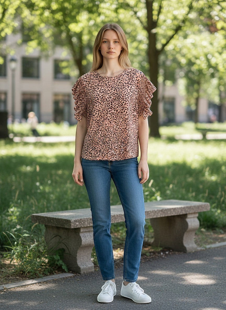 Chic Collective mauve and black leopard print top with ruffled short sleeves, worn by a model in jeans outdoors.