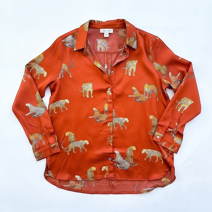 Chic Collective burnt orange satin long sleeve button-up shirt with a repeating leopard print pattern.