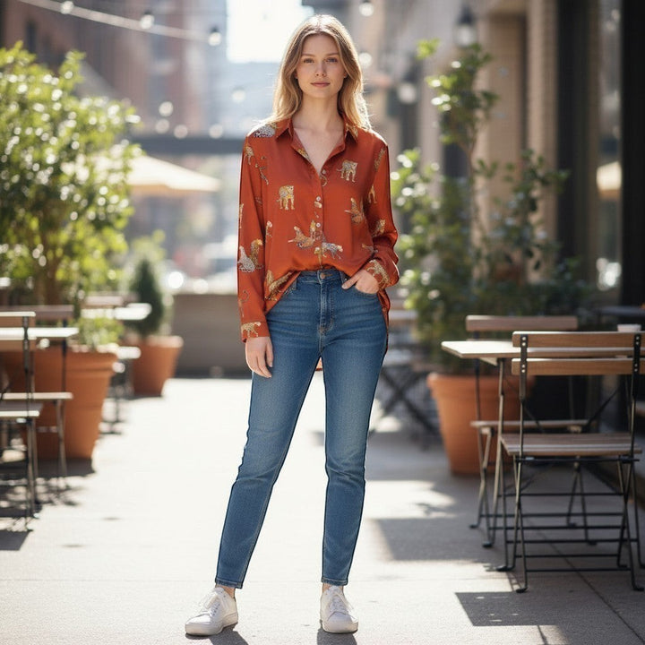 Chic Collective rust orange long-sleeve button-up shirt with a gold leopard print, paired with blue denim jeans.