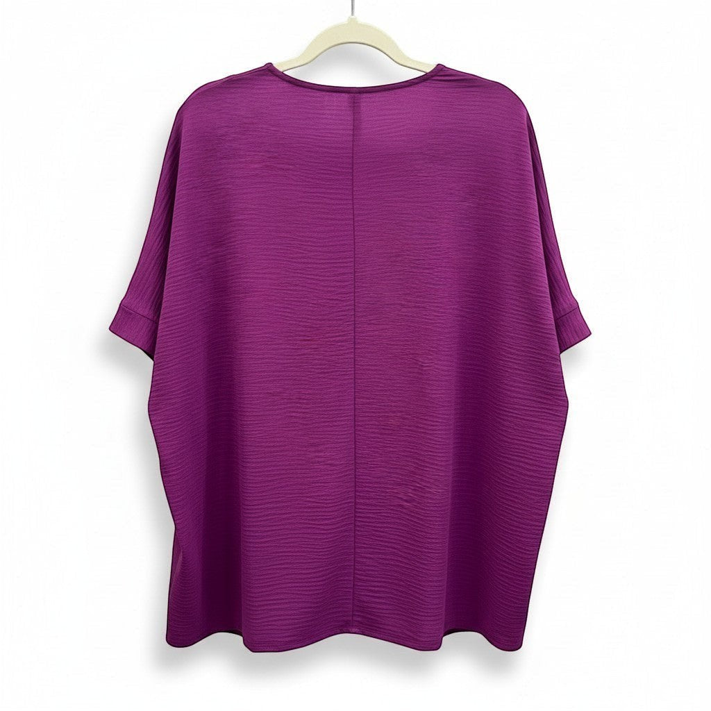 Chic Collective light plum woven dolman top with V-neck and textured fabric. Short dolman sleeves with cuffed hems.