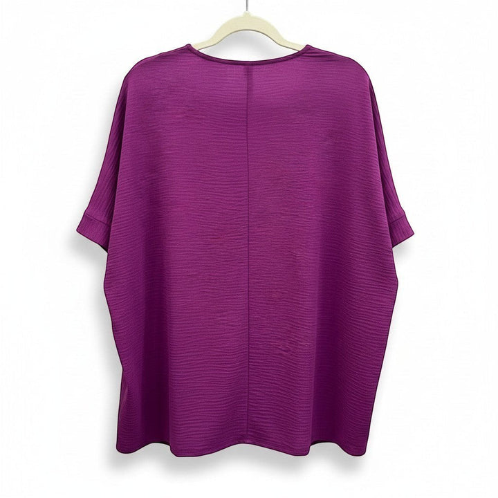 Chic Collective light plum woven dolman top with V-neck and textured fabric. Short dolman sleeves with cuffed hems.