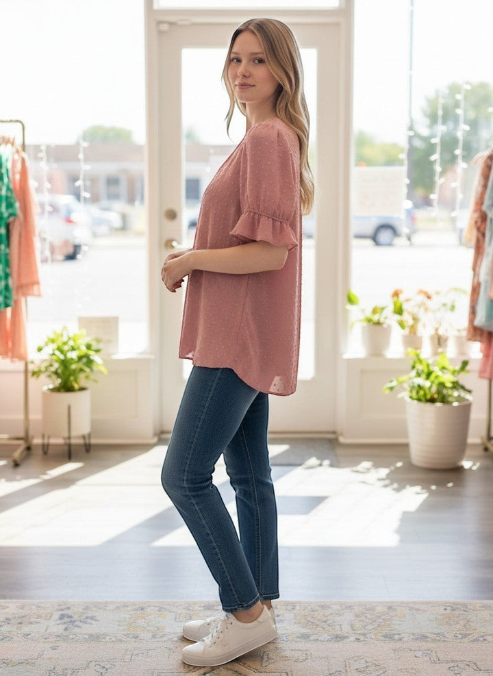Chic Collective mauve Swiss dot v-neck top with ruffled short sleeves worn by a woman with blonde hair.