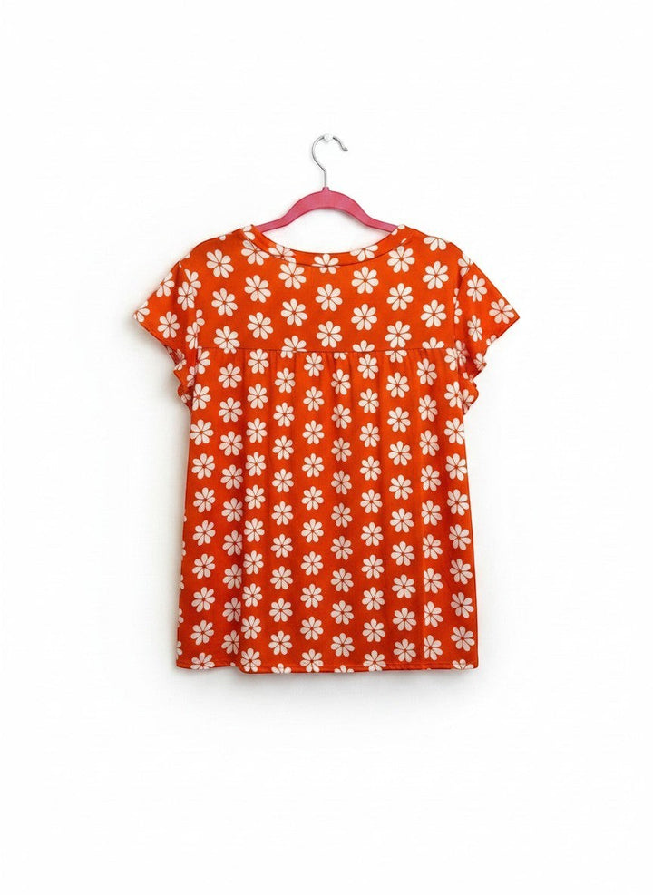 Chic Collective orange babydoll top with white daisy print and flutter sleeves.