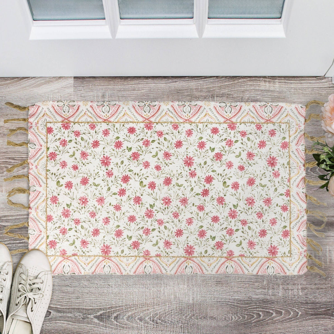 Chic Collective pink floral cotton and chenille rug with border and tassels. Watercolor-style garden design.