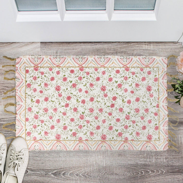 Chic Collective pink floral cotton and chenille rug with border and tassels. Watercolor-style garden design.