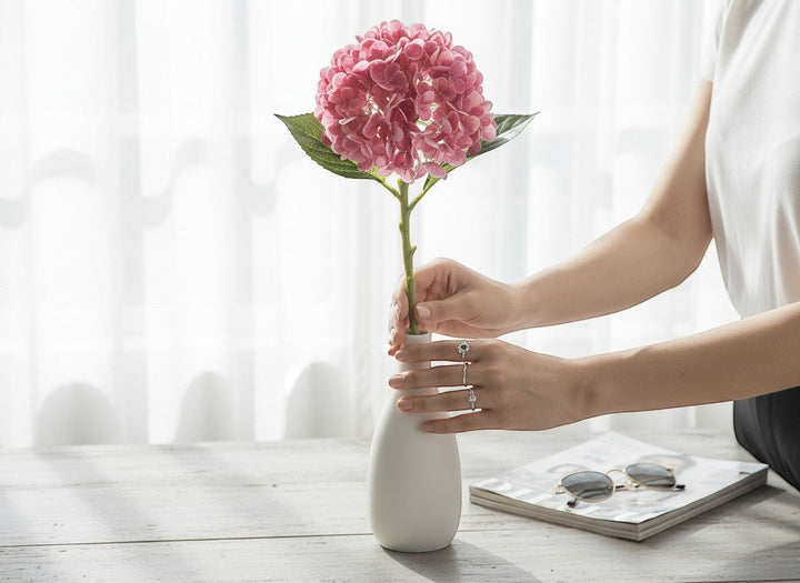 Chic Collective pink real touch hydrangea stem with green leaves in a white vase.