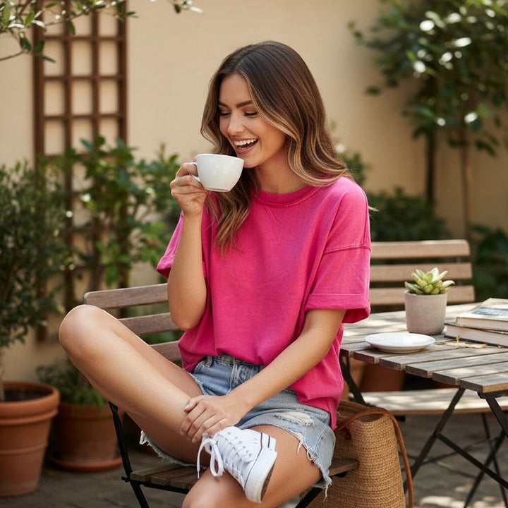 Chic Collective pink mineral wash oversized cotton blend t-shirt with cuffed sleeves, worn by a woman sitting outdoors.