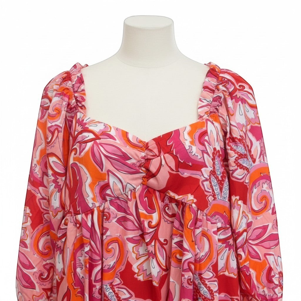 Chic Collective babydoll top with a vibrant pink, red, and orange paisley print. Features a sweetheart neckline with ruching and ruffled shoulder straps.