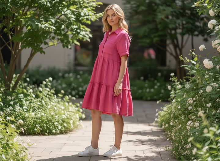 Chic Collective pink textured tiered midi dress with short sleeves and collar, worn by a model outdoors.