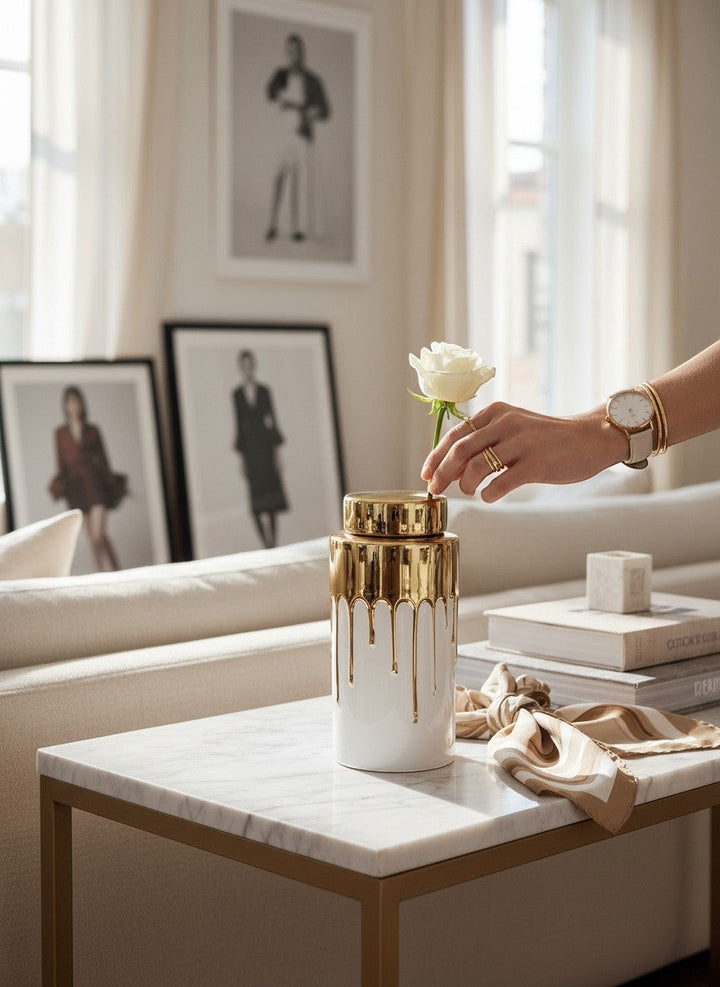 Chic Collective white ceramic jar with gold lid and dripping gold glaze design, a white rose is placed inside.