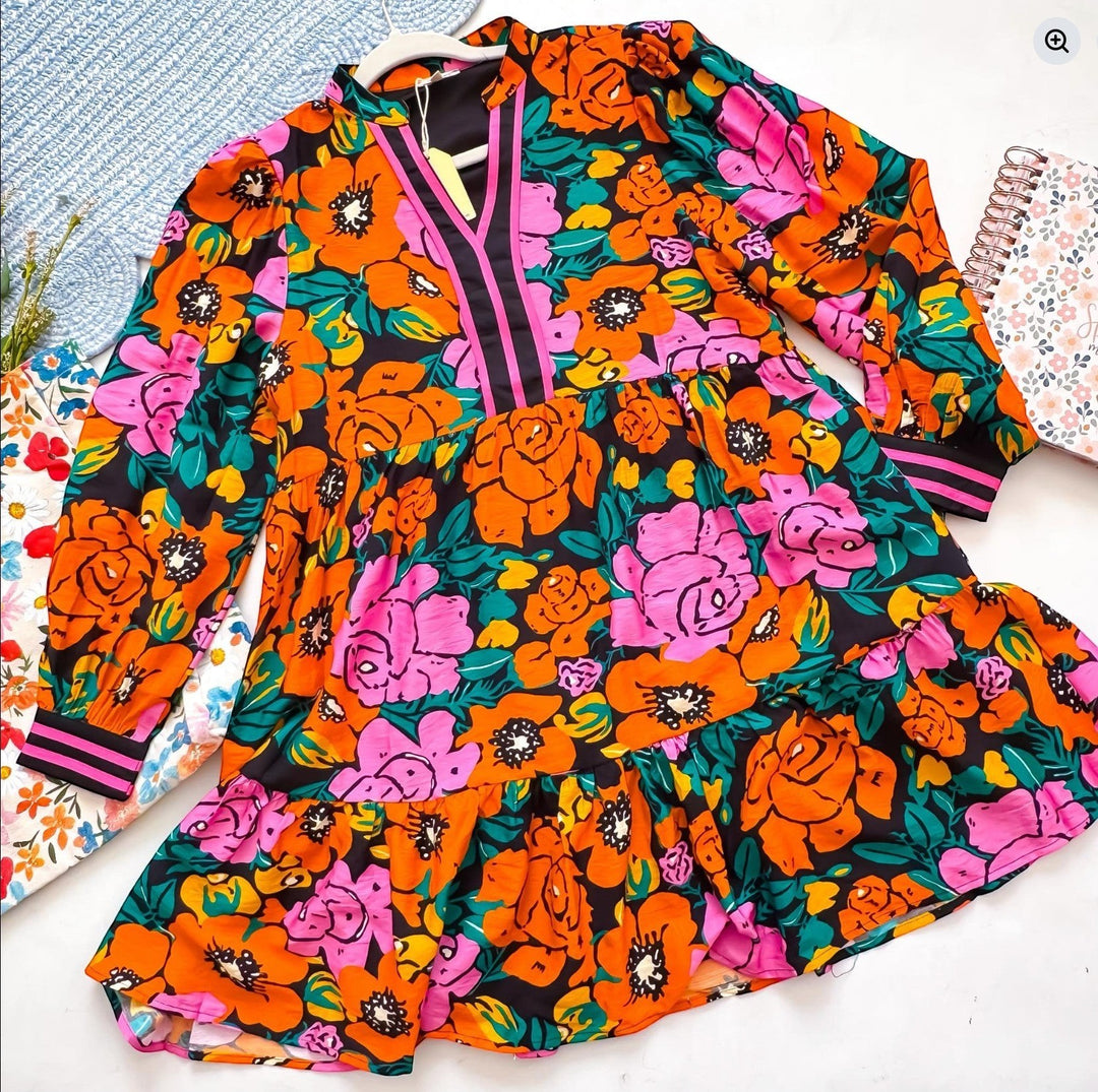 Chic Collective colorful floral print dress with long sleeves, V-neck, and tiered ruffle hem. Features pink, orange, and green flowers on a black background.